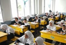 Afghan girls studying at school desks