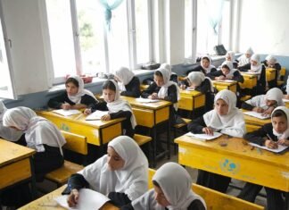 Afghan girls studying at school desks